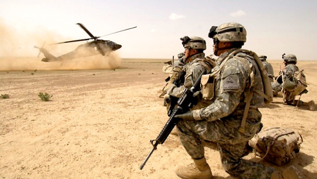 060322-F-7823A-121 U.S. Army soldiers assigned to the 1st Brigade, 1st Armored Division wait to board a UH-60 Black Hawk helicopter during an air assault mission in the Al Jazeera Desert, Iraq, on March 22, 2006. DoD photo by Staff Sgt. Aaron Allmon, U.S. Air Force. (Released)